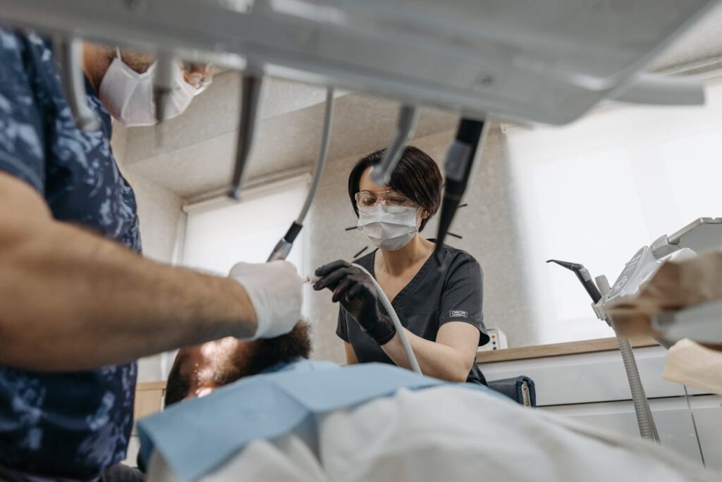 dentist fixing a patients toothache with dental nurse