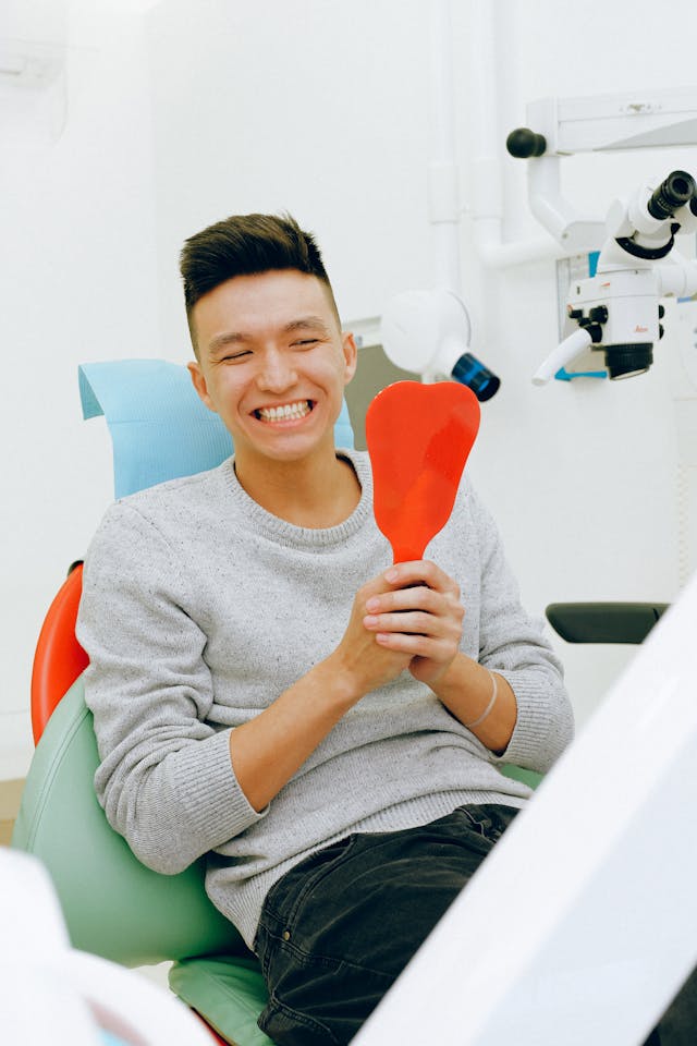 man smiling looking at dental fillings in mirror