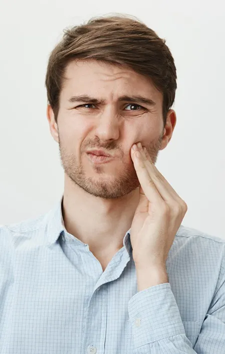 Caucasian male holding side of face due to tooth abscess pain