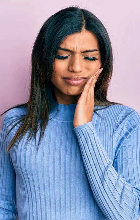 black woman holding face with tooth abscess