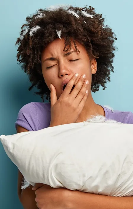 Afro hair woman snoring holding pillow