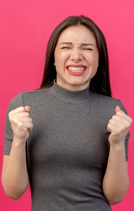 woman in grey grinding her teeth