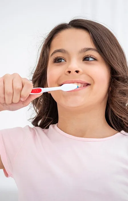 young girl brushing teeth with toothbrush