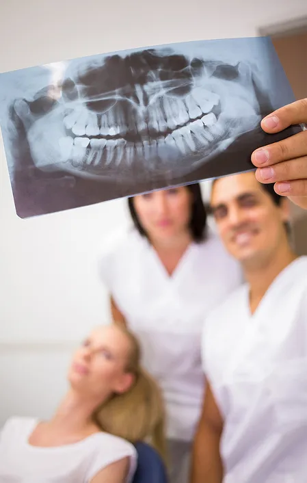 dentist holding up opg x-ray looking at impacted wisdom teeth
